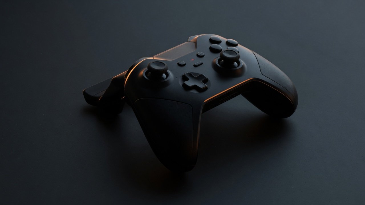A wireless game controller on a dark surface